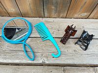 All four items laid out: mirror, comb, brown clip, black clip