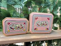 Front view of both tins showing design and sizes