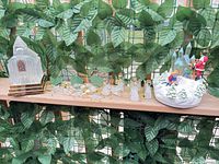 Group view of glass church, acrylic ornaments, and ceramic music box displayed on shelf