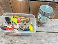 plastic tub of mixed keys and key tags beside glass jar of buttons
