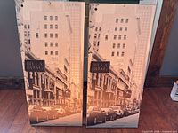 Front view of both panels showing cityscape and portrait designs