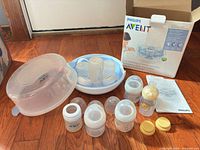 Lot overview showing sterilizer, bottles, caps, manual, box