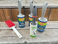 Group shot of three Scotch-Brite lint rollers, one Frank lint roller, and one red fabric pet-hair brush