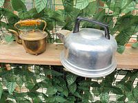 Aluminum kettle and brass teapot side by side