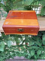 Closed wooden cigar box showing exterior wood tones and latch