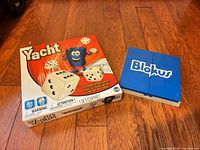 Front view of Yacht game box and closed Blokus To Go case