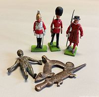 Group view of three soldiers and two bronze figures