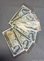 Six Canadian $1 bills fanned in sleeves