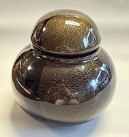 Front view of lidded jar showing overall form and gold fleck pattern