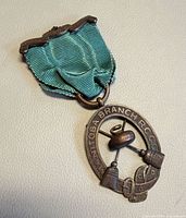 Front view of medal showing ribbon and oval pendant