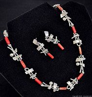 Necklace and earrings set laid out to display design and condition