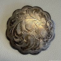 Front view showing engraved floral design and scalloped edge