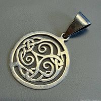 front view of round silver pendant with knot design