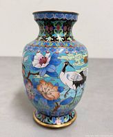 Front view of cloisonné vase showing cranes and blue flower motifs