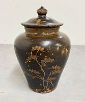 Front view of wooden urn with lid showing gold floral design