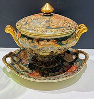 Front view of lidded tureen on underplate showing overall design and colours