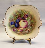 Front view showing fruit motif, handles and gilt rim