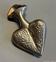 Front view showing heart shape and scroll engraving