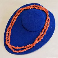 Full necklace coiled on blue surface showing overall length and bead style