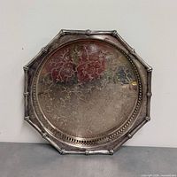 Front view of silver plated tray showing floral etching and octagonal bamboo rim
