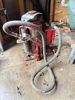 Full view of red 20-ton bottle jack with hose and springs