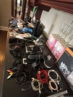 Countertop view of entire lot showing mixed cables, chargers, Nest pucks, speakers and router