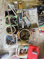 Top-view of multiple buckets and bins with assorted hardware pieces and tubing