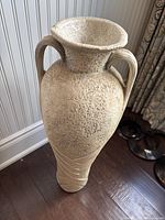 Full view of beige ceramic amphora floor vase showing double handles and flared rim
