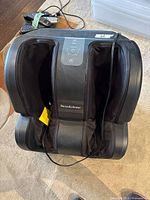 Front view of Brookstone foot and calf massager showing leg sleeves and branding