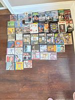 Overall lot showing arrangement of CDs and VHS tapes on floor