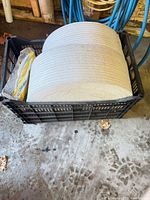 Crate holding two large coils of off-white foam window seal rolls and packaging