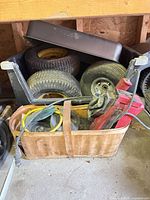 overall lot showing tires, wheels, red belt sander, belts and basket