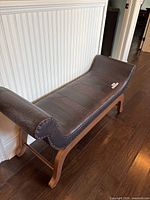 Full view of dark brown crocodile-embossed faux leather bench with nailhead trim and wooden legs