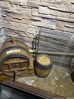 Front view of large barrel with tap, small barrel beside it and stand underneath