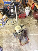 Full view of pump on wheeled frame with hose and surroundings