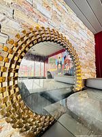 Full view of round mirror mounted on stone wall