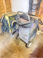 Front and side view of welder on dolly with coiled leads