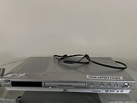 Front view of JVC XV-N44 player on glass table with power cord