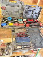 Overall view showing open cases with slide hammer parts, bushing set, two closed cases, and multimeter