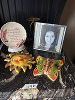All five home decor items placed on a countertop: picture frame, plaque, candle holder, sun and butterfly wall hangings