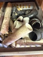 Bin containing mixed PVC and ABS fittings: straight pipes, elbows, couplings