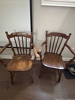 Front view of both armchairs showing spindle backs and seats