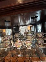 Full set displayed in cabinet: teapot, sugar bowl, creamer, six teacups and saucers
