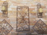 Full view showing five wrought iron pieces mounted on stone wall