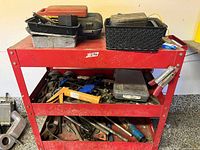 overall view of red rolling cart with assorted tools on three shelves