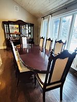 Overall view of mahogany dining table with chairs shown for scale