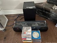 Sony CFS-W303 boombox, external subwoofer and stack of CDs on floor