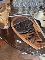 wood wall plaque and ceramic elephant figurine on table