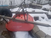Red County metal tub, wooden handles, black pneumatic wheel and metal frame shown on ground