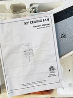 Owner’s manual for 52" ceiling fan model 51631/51632 on top of packed components